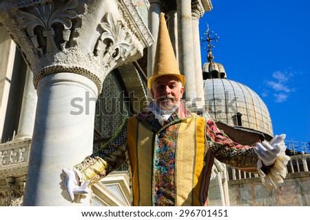 VENICE, ITALY - FEBRUARY 16, 2015: Unidentified man in carnival costume in St Mark\'s Square (St Mark\'s Basilica at background). Venice Carnival is annual event which ends on Shrove Tuesday.