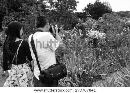 GIVERNY, FRANCE - JULY 12, 2015: Tourists take photo of Claude Monet\'s house and gardens. Located one hour ride from Paris, house of founder of French Impressionism is a popular tourist destination.