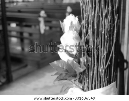 Beautiful white roses  wedding decoration in the church. Retro aged dreamy image. Blurred unfocused photo. Black and white.