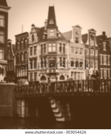 Amsterdam houses and bridge over the canal in cloudy day. Blurred toned photo.