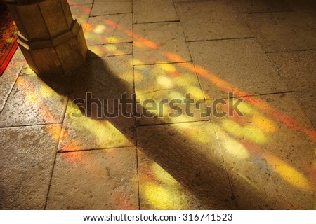 Colorful light spots on the the floor in church. Sunlight filtered through the stained glass window. A game of light and shadow.