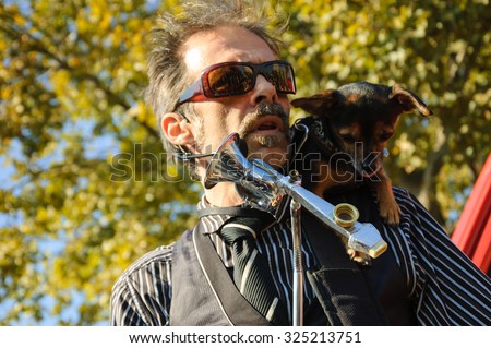 PARIS, FRANCE - OCTOBER 3, 2015:  Unidentified musician and his dog play and sing amusing the participants of Zombie parade at Place de la Republique. Zombie Walk is an annual event in Paris.
