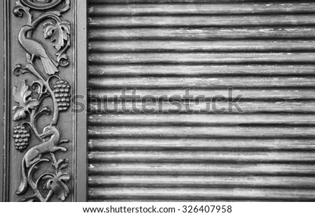 Architectural detail. Fragment of metal gate with decorative frame (animals and grapes pattern). Burgundy, France. Vintage background. Aged photo. Black and white.