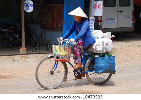 typical ninja style face-covered woman riding bicycle in Vietnam