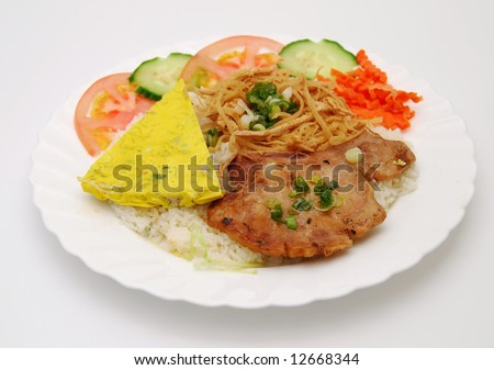 Closeup of vietnamese food: steamed rice dish with egg/meat pie and BBQ pork chop