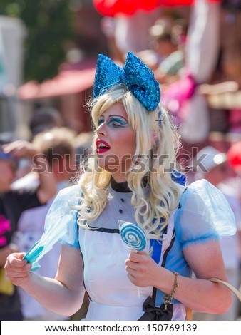 STUTTGART, GERMANY - JULY 27th, 2013 - Man dressed as Alice in Wonderland participates at the Christopher Street Day (CSD) parade in Stuttgart circa July 2013. The CSD is an annual gay-pride parade.