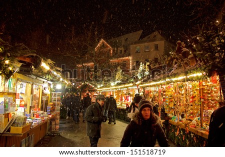 ESSLINGEN, GERMANY - DEC 11TH, 2012: People stroll down an aisle at the Christmas Market at night circa December 2012 in Esslingen. Esslingen is famous for its annual medieval Christmas Market.