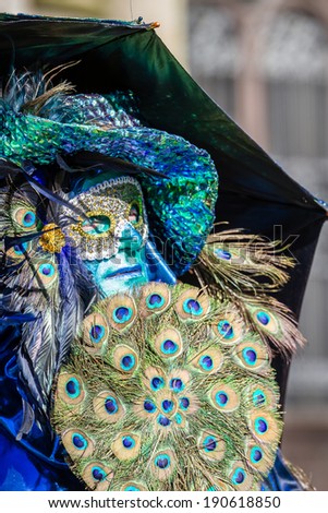 SCHWAEBISCH-HALL, GERMANY - February 23, 2014 - Man, dressed up in a Venetian style costume, holding a peacock feather fan, attends the Hallia Venetia festival on February 23, 2014 in SchwÃ?Â¤bisch-Hall.