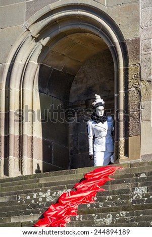 SCHWAEBISCH-HALL, GERMANY - February 23, 2014 - Woman, dressed up in a Venetian style costume peeks out of a medieval doorway at the Hallia Venetia Carnival on February 23, 2014 in SchwÃ?Â¤bisch-Hall.