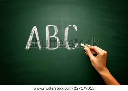 abc letters with hand and chalk on blackboard