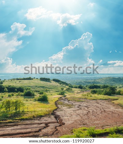 blue sky with clouds and sun over drought earth in mountains
