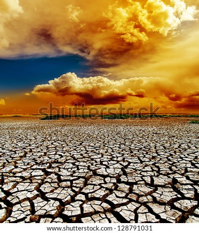 dramatic sunset over dry cracked earth