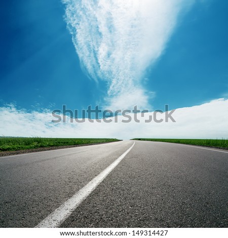 asphalt road to cloudy horizon in blue sky