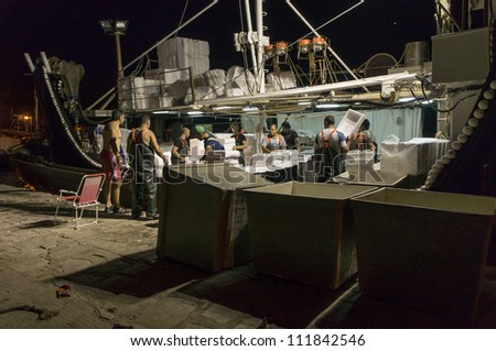 MARONIA, GREECE - JULY 9: Commercial fishermen delivering the sardines night\'s catch  on July 9, 2012 in Maronia, Greece