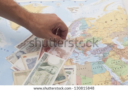greek drachmas and euro banknote with a hand selection on a europe map