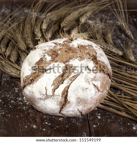 fresh traditional bread with wheat on a wooden table