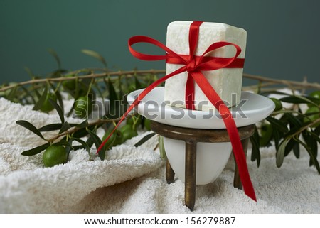 Handmade olive soap with olive branch and a towel, as a gift.