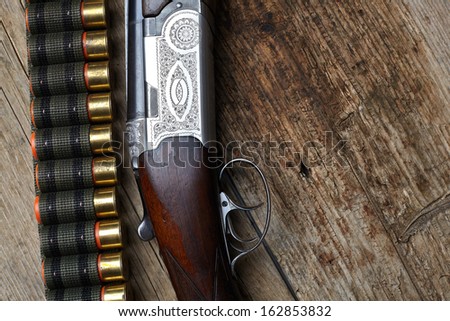 vintage hunting gun with cartridges on wooden background