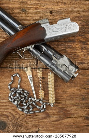 hunting gun with cleaning kit on a wooden table