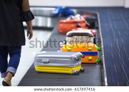 Wheeled suitcase on a luggage belt at the airport terminal.