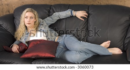 Beautiful girl laying on black leather couch