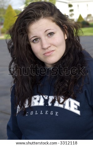 Teenage girl portrait outside with brunette hair blowing in the wind