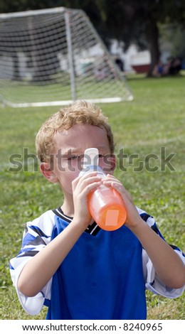 Young boy having orange drink during halftime of soccer game