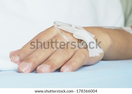 close up shot IV solution in a male patient\'s  hand