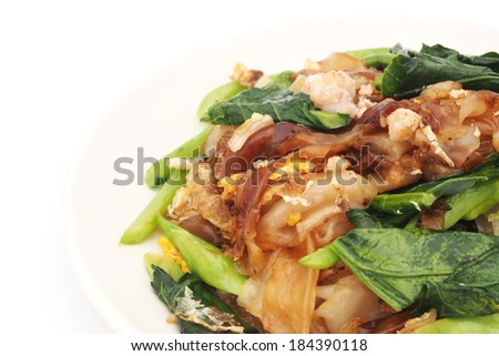 fired thin noodles with soy sauce and chinese kale,close up