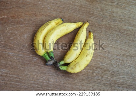 ripe small bananas on wood