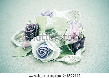 artificial roses and lace on brown paper grunge , dark blue vintage style