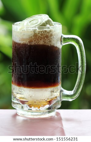 Root beer float, a tasty summer treat.on Green tree background