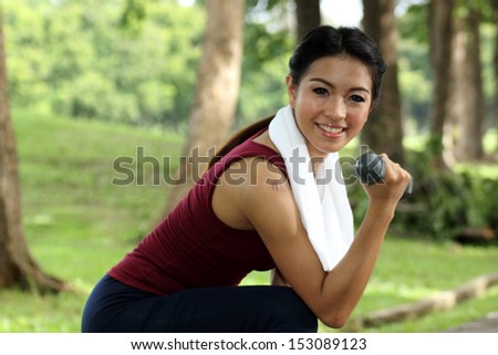 woman jogging on running trail with hand weights