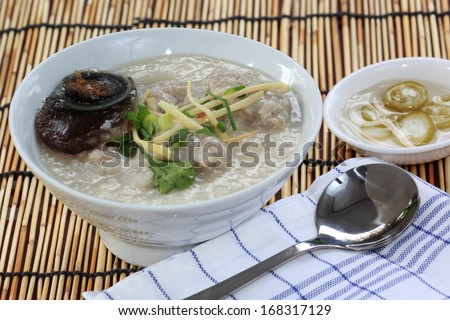 Traditional chinese porridge rice gruel in bowl with pork and Preserved egg