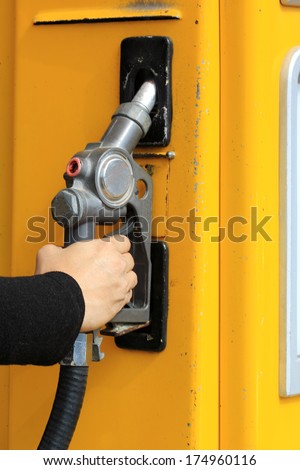 hand of male holding a fuel pump at gasoline station