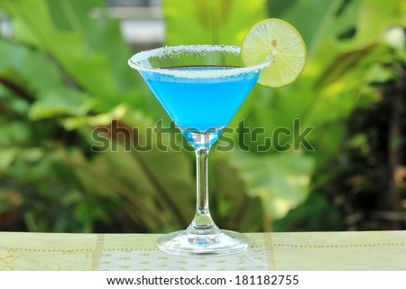Blue margarita Cocktail in the garden background