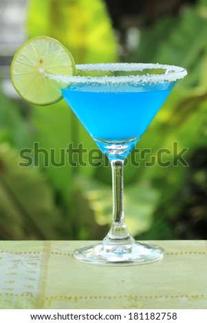 Blue margarita Cocktail in the garden background