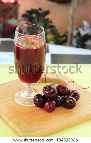 Cherry juice and cherries on the table