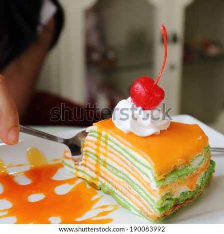 Orange crepe cake and orange jam topping with cherry