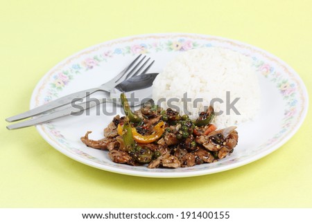 Stir fried beef with black hot pepper and steam rice on the plate