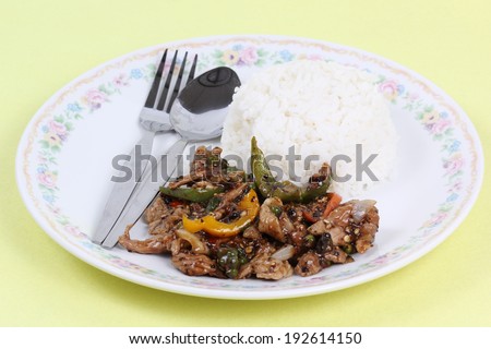 Stir fried beef with black hot pepper and steam rice on the plate