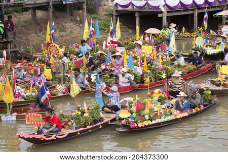 AYUTTHAYA, THAILAND - JULY 11: Unidentified people on flower boats in floating parade, the unique annual candle festival of Buddhist lent on July 11, 2014 in Ladchado, Ayutthaya, Thailand