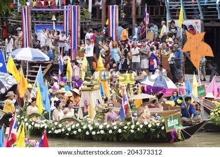 AYUTTHAYA, THAILAND - JULY 11: Unidentified people on flower boats in floating parade, the unique annual candle festival of Buddhist lent on July 11, 2014 in Ladchado, Ayutthaya, Thailand