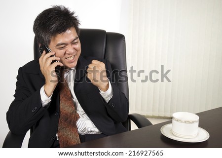 Businessman feeling happy at work/Asian businessman working with the desk