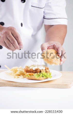 chef preparing a burger on the table