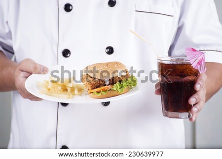 chef present a burger and cola drink on the studio