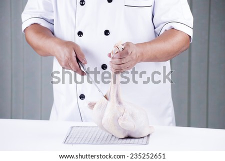 Chef prepared chopping raw chicken before cooking