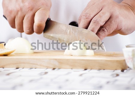 Chef cutting the onion on a wooden board/ Cooking Japanese curry concept