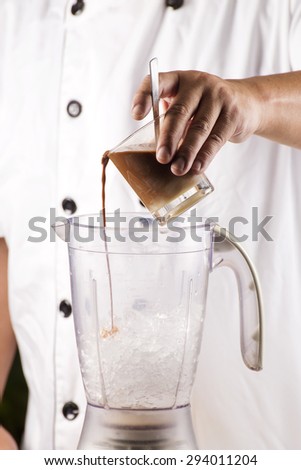Chef putting coffee to blender with ice