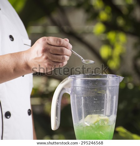 Chef putting Salt to the Blender for making green apple smoothie